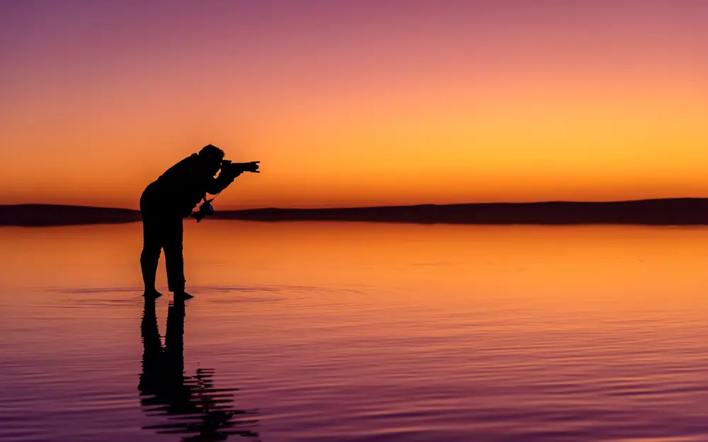 Photographer at sunset on a salt lake